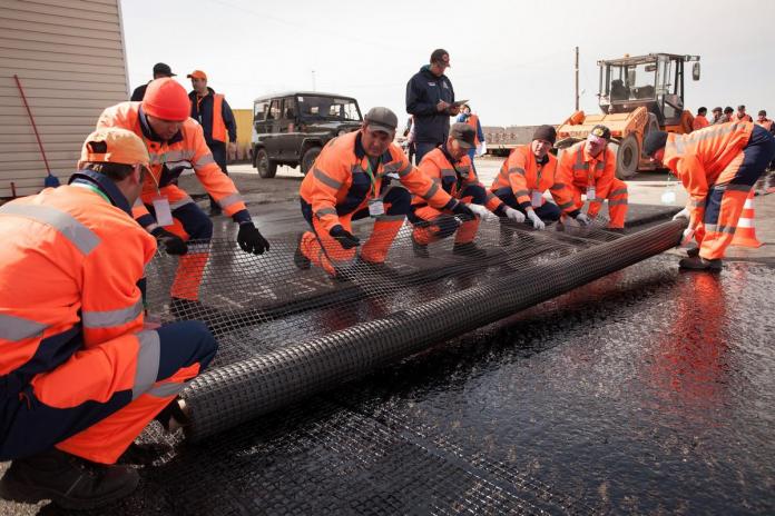 Команда Барабинского ДРСУ прибивает армирующую геосетку гвоздями к старому покрытию